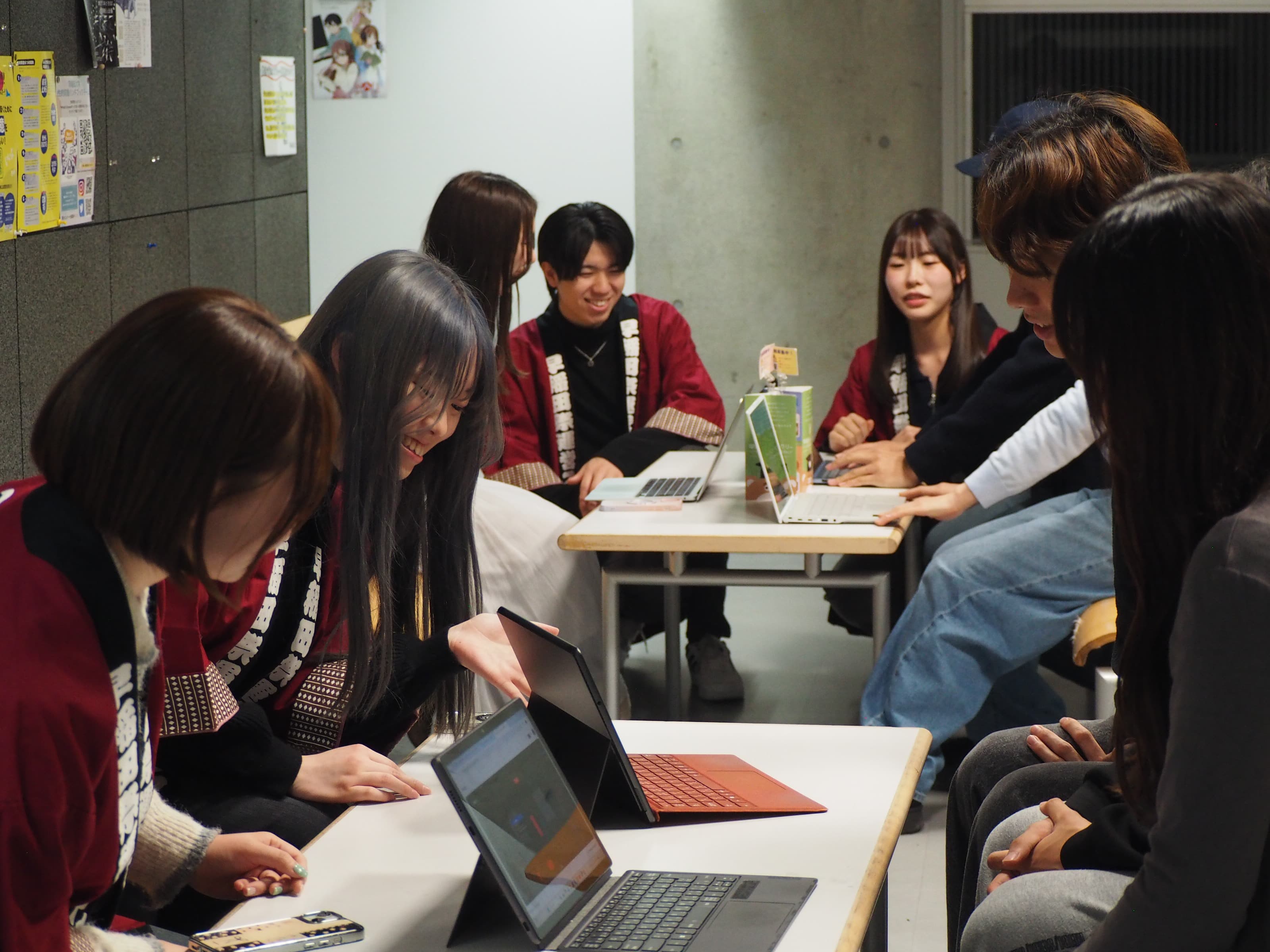 パソコンを見せて説明するスタッフとそれを聞く新入生