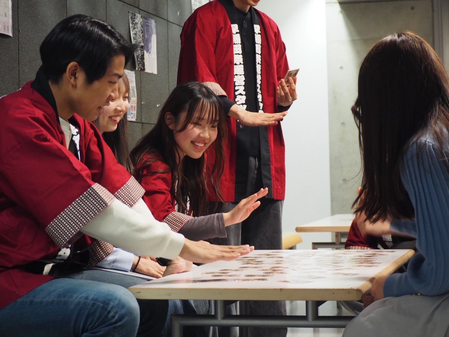 かるたをしている新入生と運営スタッフ