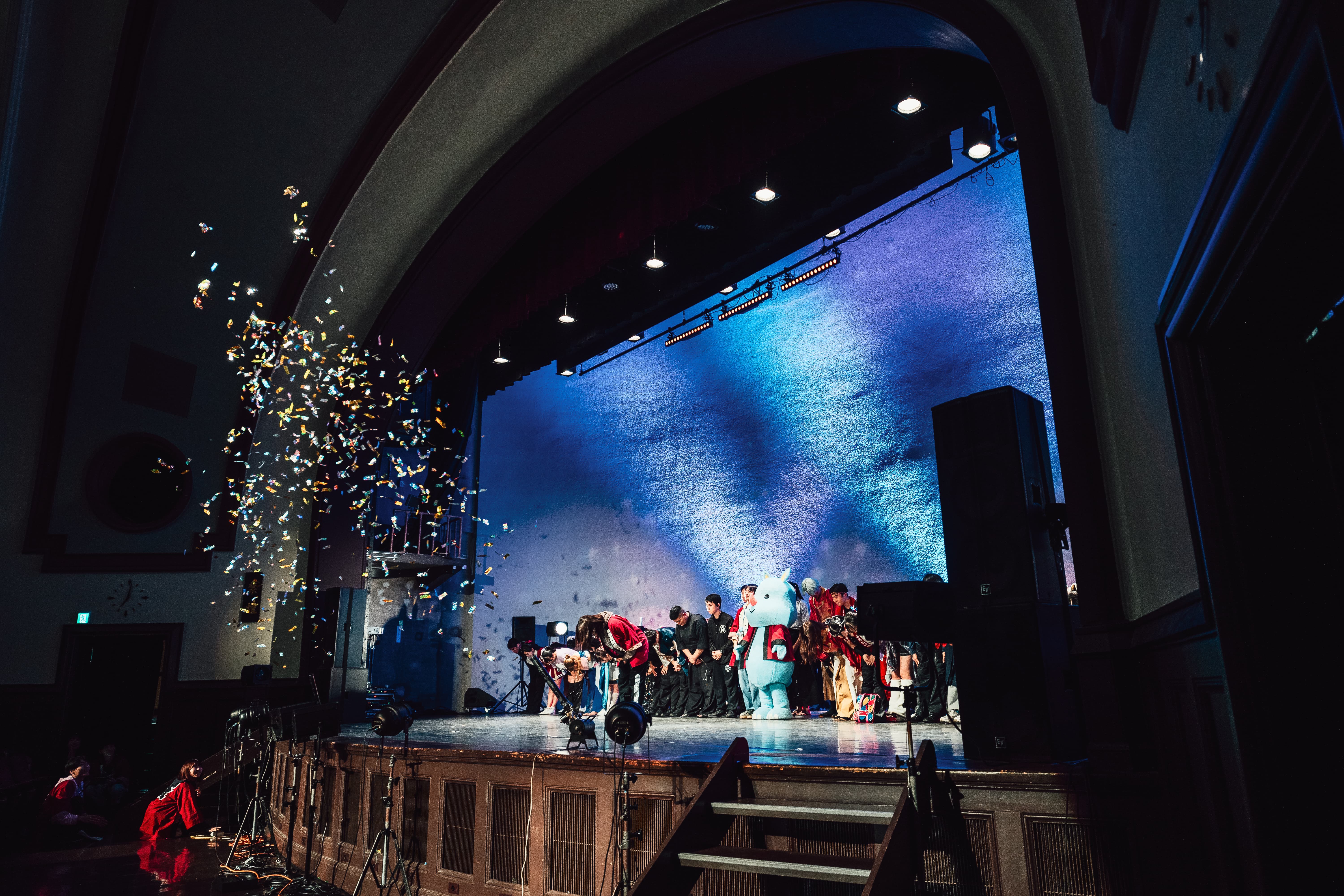 講堂でお辞儀をする運営スタッフ